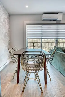 a table and chairs in a room with a balcony at Burgundy Lofts - Marché Atwater in Montréal