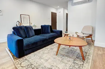 a living room with a blue couch and a table at Burgundy Lofts - Marché Atwater in Montréal