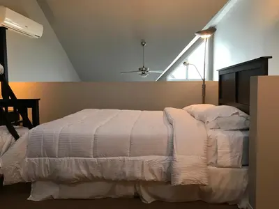 a bedroom with a white bed with a window at Bromont-Condo sur la montagne in Bromont