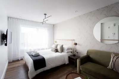 a white bedroom with a bed and a couch at Wonderful Studio in Little Italy with full bath by Den Stays in Montréal