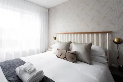 a bedroom with a bed with white sheets and pillows at Wonderful Studio in Little Italy with full bath by Den Stays in Montréal