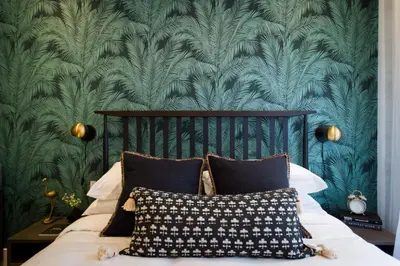a bedroom with a bed with a green wallpaper at Sunny Green Palms Micro Studio with Yard View by Den Stays in Montréal