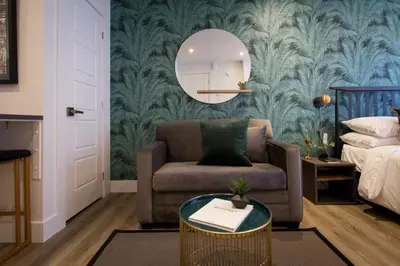 a living room with a couch and a mirror at Sunny Green Palms Micro Studio with Yard View by Den Stays in Montréal