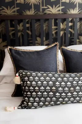 a bed with black and white pillows on it at Sunny Green Palms Micro Studio with Yard View by Den Stays in Montréal