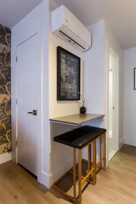 a kitchen with a desk and stool next to a door at Fun & Funky Little Italy Studio with Full Kitchen by Den Stays in Montréal