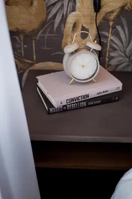a clock sitting on top of a stack of books at Fun & Funky Little Italy Studio with Full Kitchen by Den Stays in Montréal
