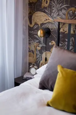 a bedroom with a bed with a wallpaper with birds at Fun & Funky Little Italy Studio with Full Kitchen by Den Stays in Montréal