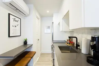 a kitchen with white cabinets and a counter top at Serene and Styled Little Italy Studio full bath by Den Stays in Montréal