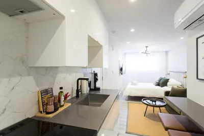 a kitchen with a sink and a room with a bed at Serene and Styled Little Italy Studio full bath by Den Stays in Montréal