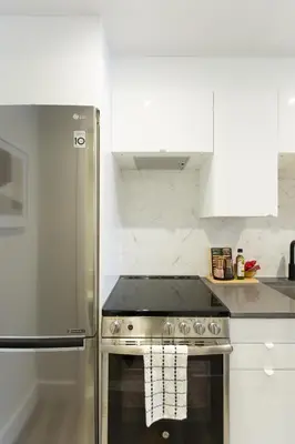 a kitchen with a stainless steel stove and a refrigerator at Serene and Styled Little Italy Studio full bath by Den Stays in Montréal