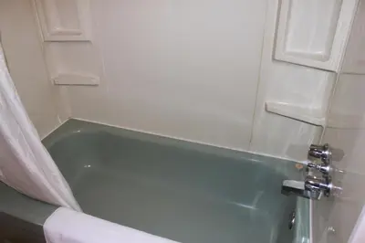 a bathroom with a green bath tub with a shower curtain at Motel Boisé in Blainville
