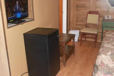 a room with a television and a table and a chair at Motel Boisé in Blainville