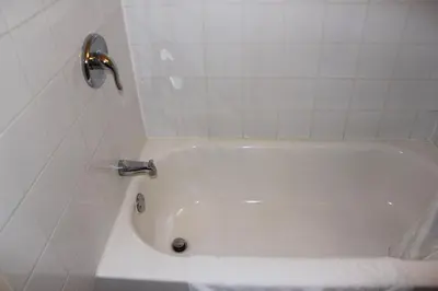 a white bath tub with a faucet in a bathroom at Motel Boisé in Blainville