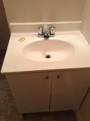 a bathroom sink with a white counter top at Motel Boisé in Blainville