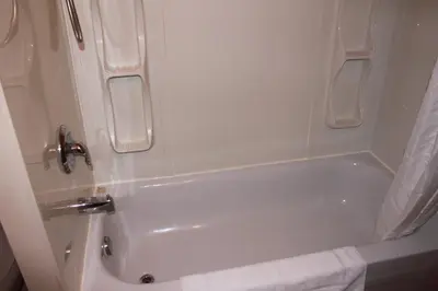a white bath tub in a small bathroom at Motel Boisé in Blainville