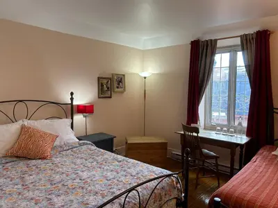 a bedroom with a bed and a desk and a window at À l'Adresse du Centre-Ville in Montréal