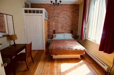 a bedroom with a bed and a brick wall at À l'Adresse du Centre-Ville in Montréal