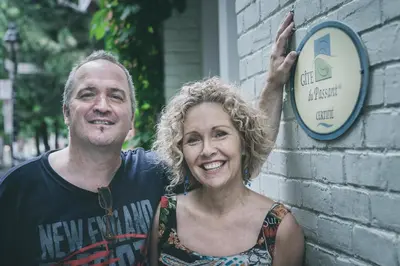 a man and a woman standing next to a clock at À l'Adresse du Centre-Ville in Montréal