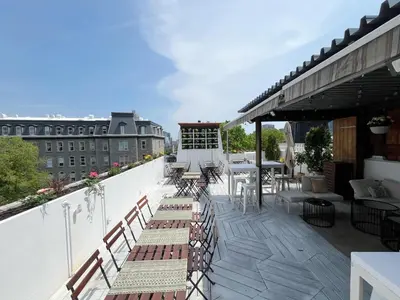a balcony with benches and tables on a building at Auberge du Plateau in Montréal