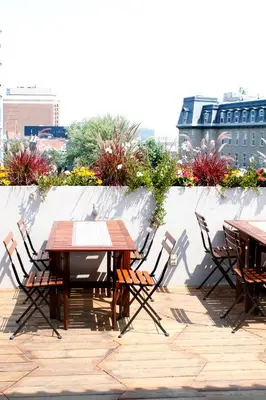 a wooden table and chairs on a patio at Auberge du Plateau in Montréal