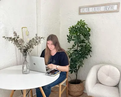 a woman sitting at a table using a laptop computer at Auberge du Plateau in Montréal