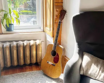 a guitar sitting next to a chair next to a window at Auberge du Plateau in Montréal