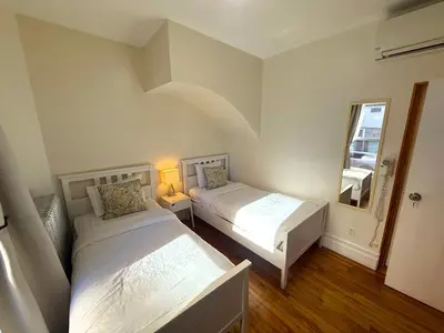a small room with two beds and a mirror at Auberge du Plateau in Montréal