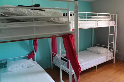 two bunk beds are in a room with blue walls at Auberge Alternative in Montréal
