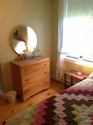 a bedroom with a dresser with a mirror on it at Gîte Au Blanc Marronnier in Racine