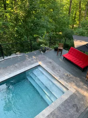a swimming pool on a deck with a red couch at La Bohème - Bed & Breakfast in Bromont