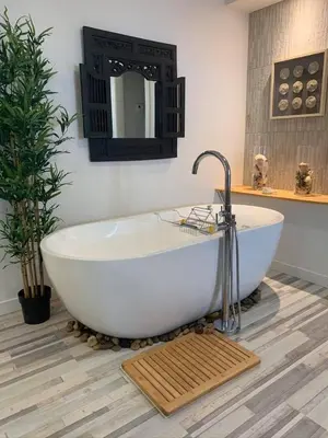 a large white tub in a bathroom with a mirror at La Bohème - Bed & Breakfast in Bromont