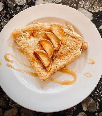 a white plate with a piece of toast with caramel at La Bohème - Bed & Breakfast in Bromont