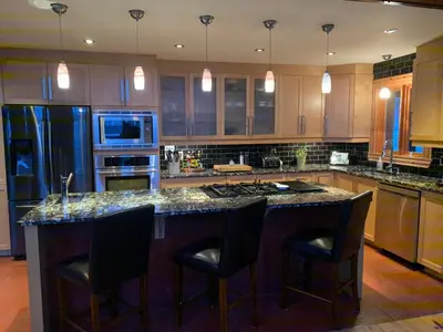 a kitchen with a large island with black bar stools at La Bohème - Bed & Breakfast in Bromont