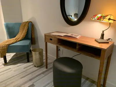 a desk and a chair with a lamp and a mirror at La Bohème - Bed & Breakfast in Bromont