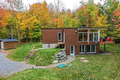 a small house in the middle of a yard at Sutton Wellness Cabin #265 unité du haut in Sutton