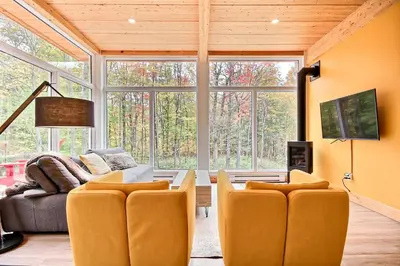 a living room with a couch and a table at Sutton Wellness Cabin #265 unité du haut in Sutton