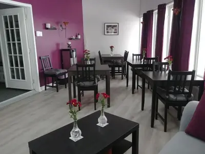 a dining room with tables and chairs with flowers on them at Dans Les Bras de Memphré in Magog-Orford