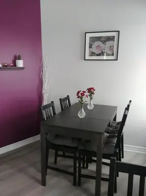 a dining room table with a vase of flowers on it at Dans Les Bras de Memphré in Magog-Orford