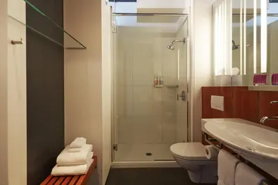 a bathroom with a shower and a toilet and a sink at Hôtel Alt Montréal in Montréal