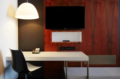 a room with a desk with a tv on a wall at Hôtel Alt Montréal in Montréal