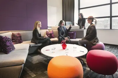 a group of people sitting around a table in a room at Hôtel Alt Montréal in Montréal