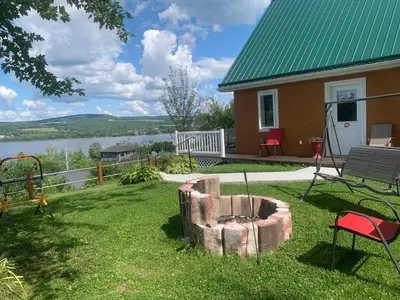 a house with a fire pit in the yard at Chalets Garou in St-Ferdinand