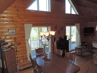 a dining room with a wooden table in a cabin at Chalets Garou in St-Ferdinand