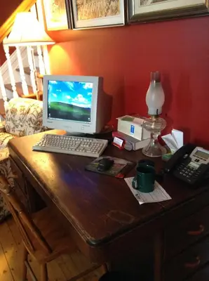 a desk with a computer monitor and a keyboard at Le Gîte des Soeurs in Saint-Luc-de-Vincennes