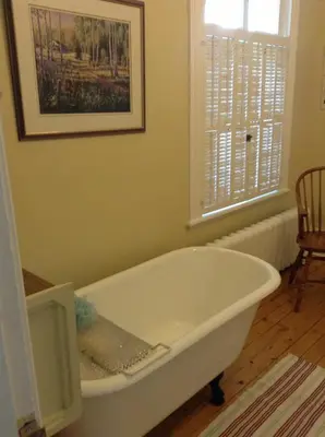 a white bath tub in a room with a window at Le Gîte des Soeurs in Saint-Luc-de-Vincennes