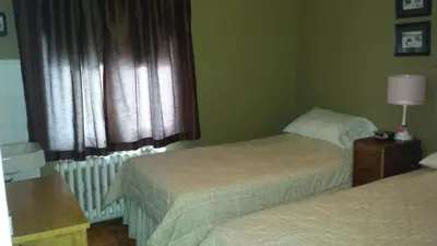 a hotel room with two beds and a window at Le Gîte des Soeurs in Saint-Luc-de-Vincennes