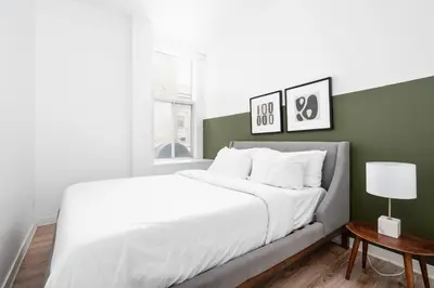 a bedroom with a white bed and a green wall at Boutique Lofts Notre Dame - Vieux Montréal in Montréal