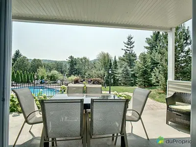 a patio with a table and chairs and a pool at Condo Le Champlain - 105 in Bromont