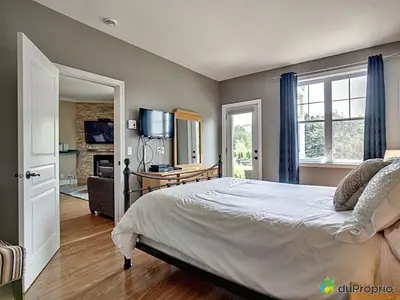a bedroom with a large bed and a television at Condo Le Champlain - 105 in Bromont