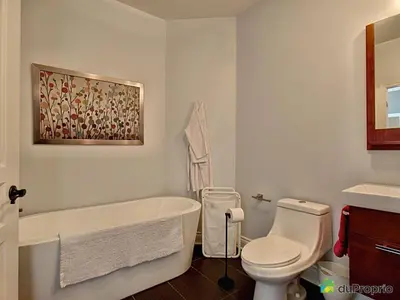 a bathroom with a tub and a toilet and a sink at Condo Le Champlain - 105 in Bromont